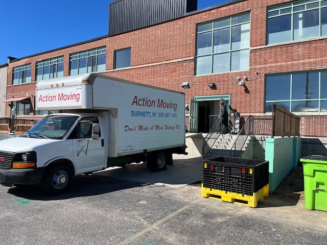 Action Moving truck backed up to a commercial building