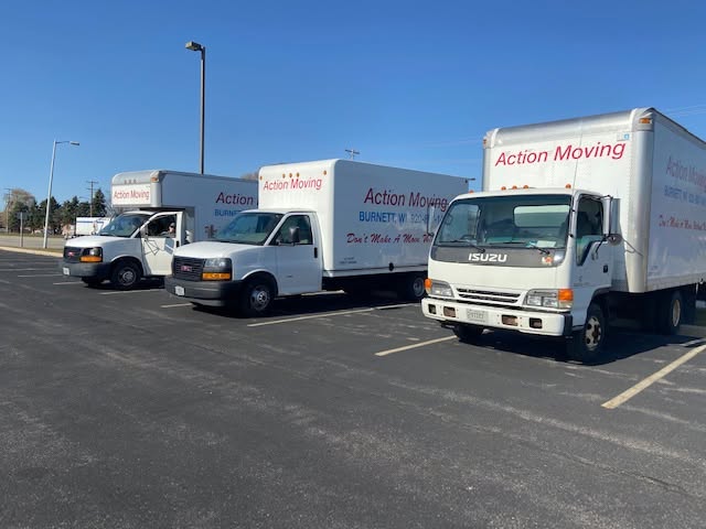 Three moving trucks parked in a lot